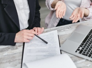 two people sitting and looking at paperwork.